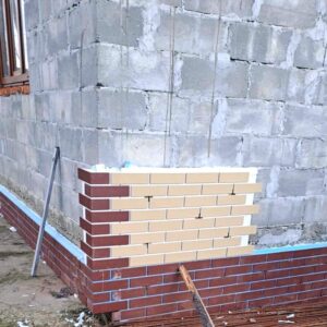 Lucrări de fațadă la izolarea unei case din regiunea Transcarpatia